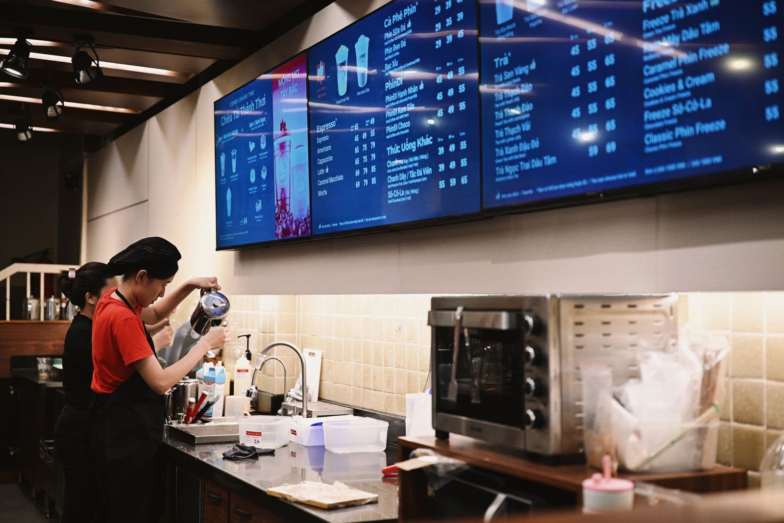 A coffee shop using a row of digital menu displays