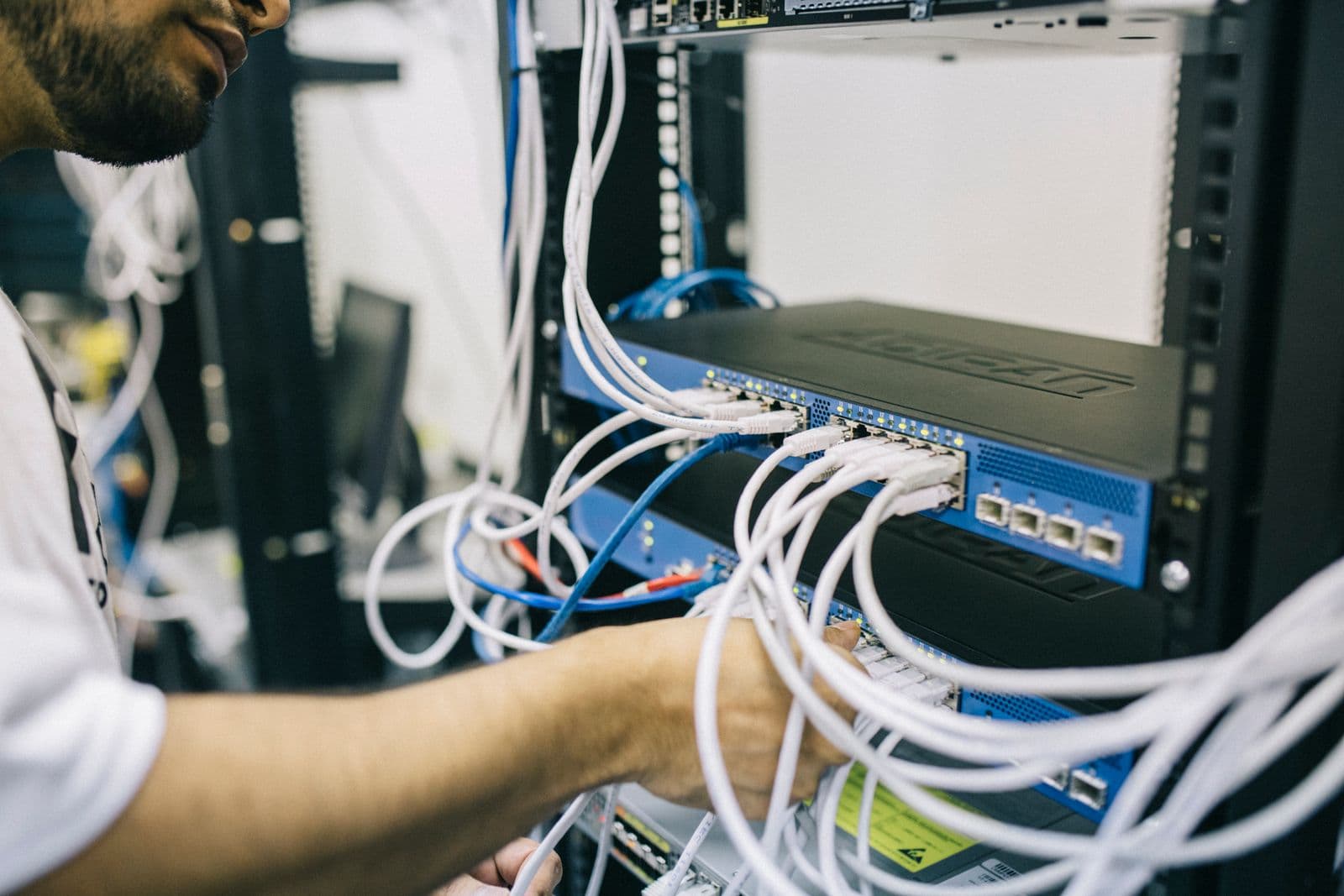 A technician configuring network equipment and cabling