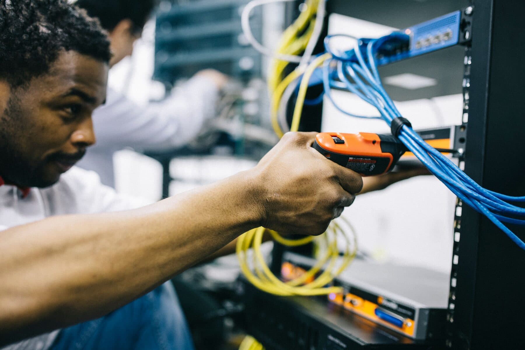 A technician working on equipment in a server rack