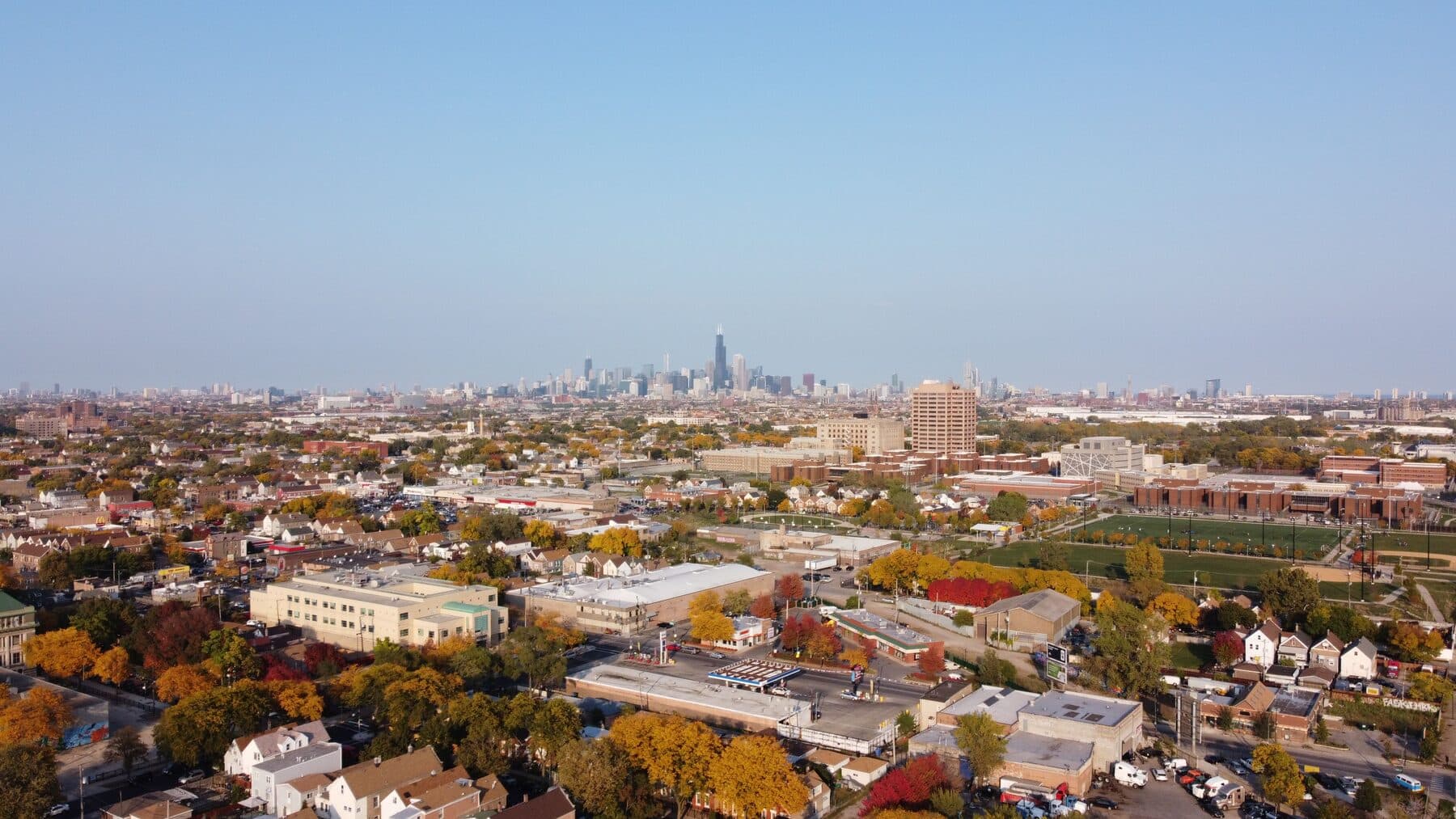 Aerial view across Chicagoland neighborhoods toward the Chicago skyline
